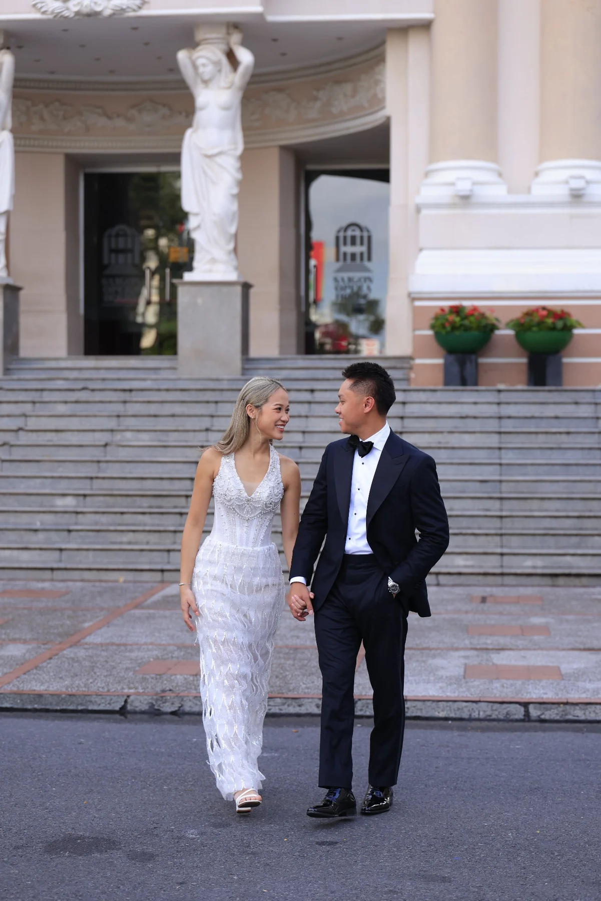 Huyen and Ryan walking together in front of the opera house